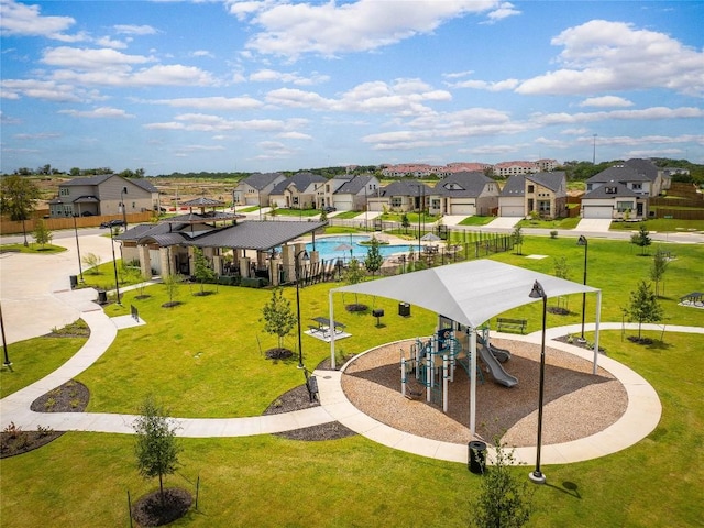 surrounding community featuring a playground, a swimming pool, and a lawn