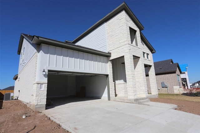 view of property exterior with central AC unit and a garage