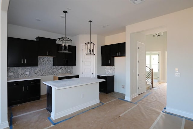 kitchen with tasteful backsplash, hanging light fixtures, and a center island