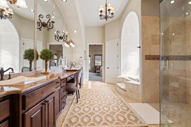 bathroom featuring vanity, a high ceiling, independent shower and bath, and an inviting chandelier