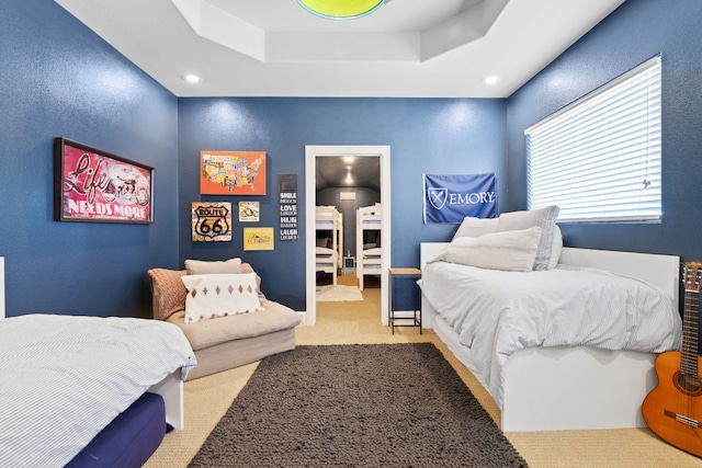 bedroom featuring carpet and a raised ceiling