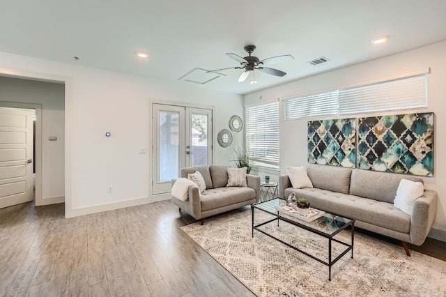 living room with ceiling fan, french doors, and light hardwood / wood-style floors