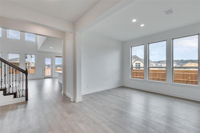 spare room with recessed lighting, visible vents, wood finished floors, baseboards, and stairs