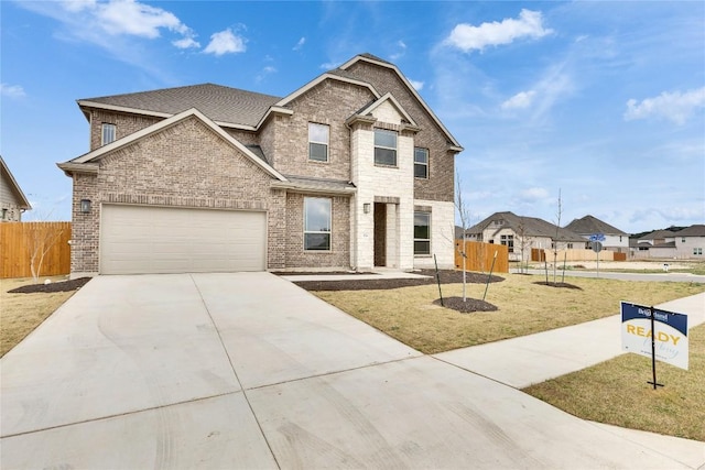 traditional-style home with brick siding, fence, a garage, driveway, and a front lawn