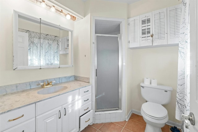 bathroom with tile patterned flooring, vanity, a shower with shower door, and toilet