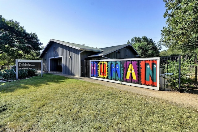 back of house featuring a yard and an outbuilding