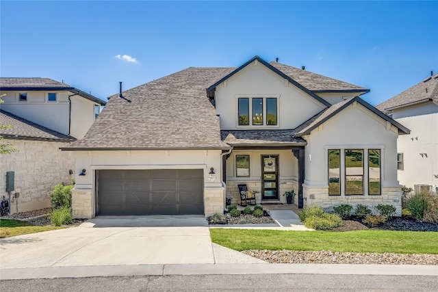 view of front of home featuring a garage, stone siding, driveway, roof with shingles, and stucco siding