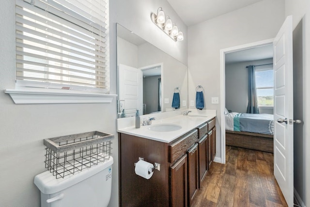 bathroom with hardwood / wood-style floors, vanity, and toilet