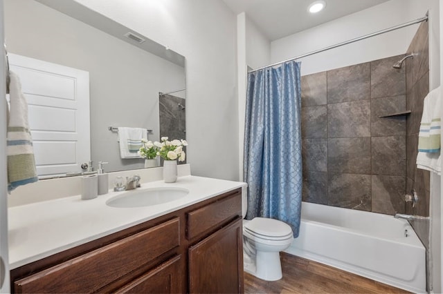 full bathroom with wood-type flooring, shower / bathtub combination with curtain, vanity, and toilet