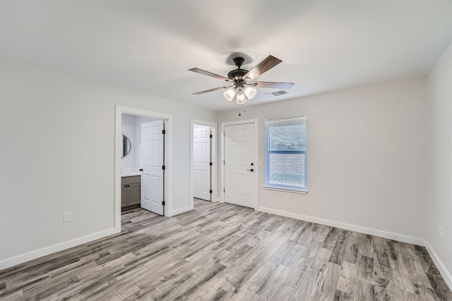 unfurnished bedroom featuring ensuite bathroom, ceiling fan, and light hardwood / wood-style flooring