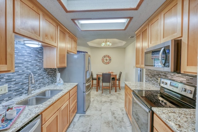 kitchen with light brown cabinets, stainless steel appliances, and sink