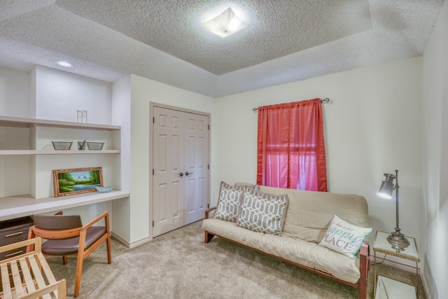 sitting room featuring light carpet and a textured ceiling