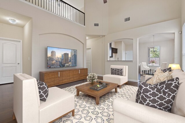 living room with a high ceiling, light wood-type flooring, and a notable chandelier