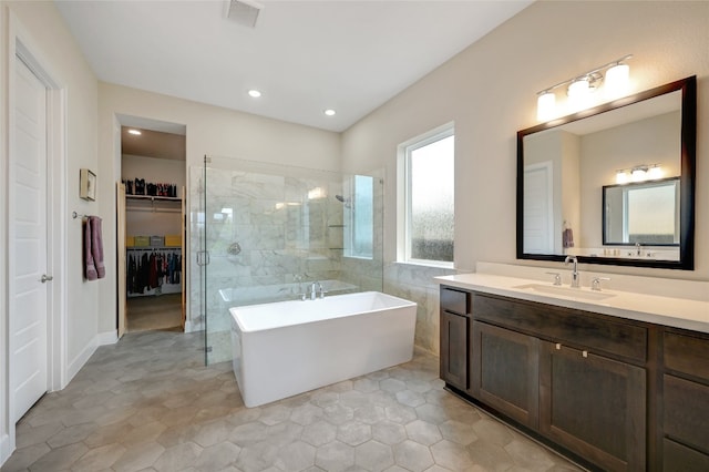 bathroom featuring plus walk in shower, tile patterned floors, and vanity