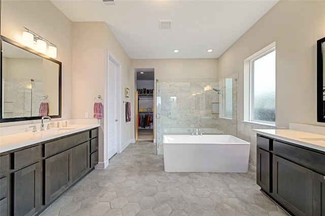 bathroom featuring tile patterned flooring, separate shower and tub, and vanity