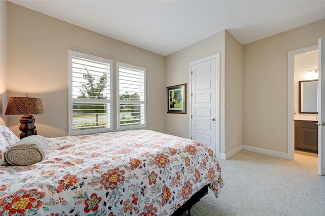 bedroom featuring light carpet and ensuite bath