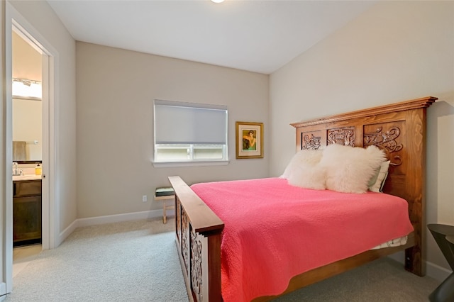 bedroom featuring sink, connected bathroom, and light carpet