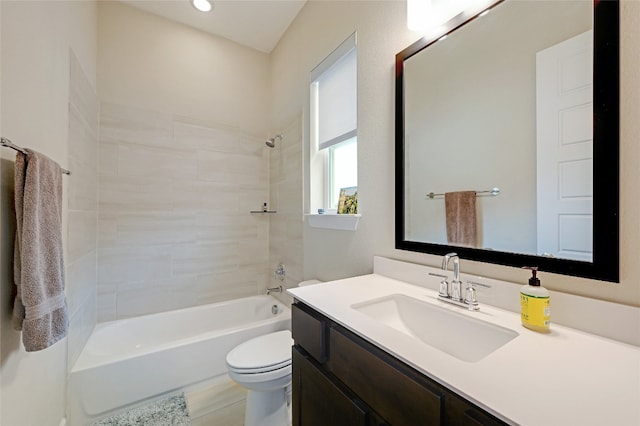 full bathroom with tiled shower / bath, vanity, and toilet