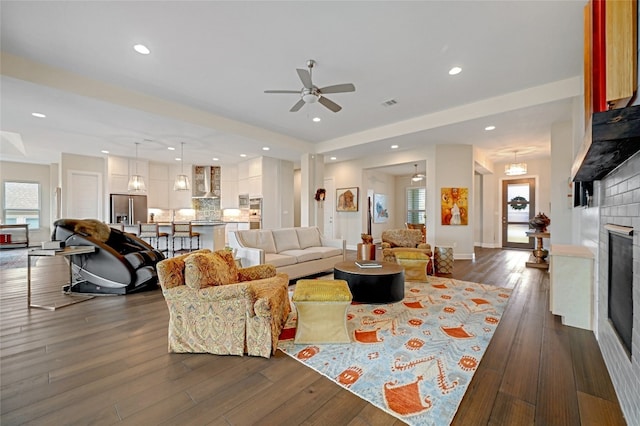 living room with ceiling fan and dark hardwood / wood-style flooring