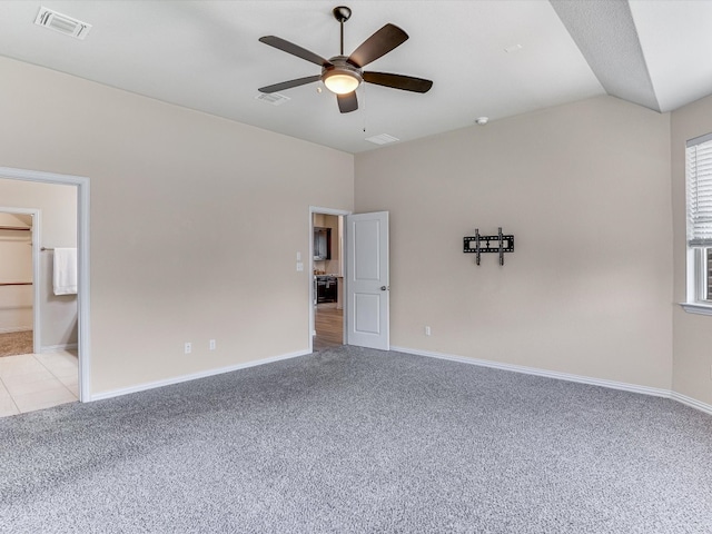 unfurnished bedroom featuring lofted ceiling, light carpet, and connected bathroom