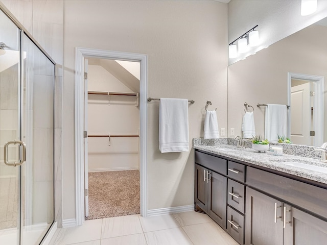 bathroom with tile patterned floors, vanity, and walk in shower