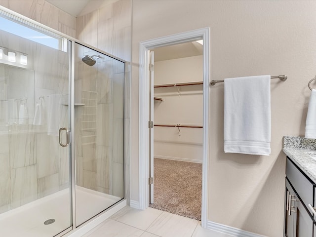 bathroom with walk in shower, vanity, and tile patterned floors