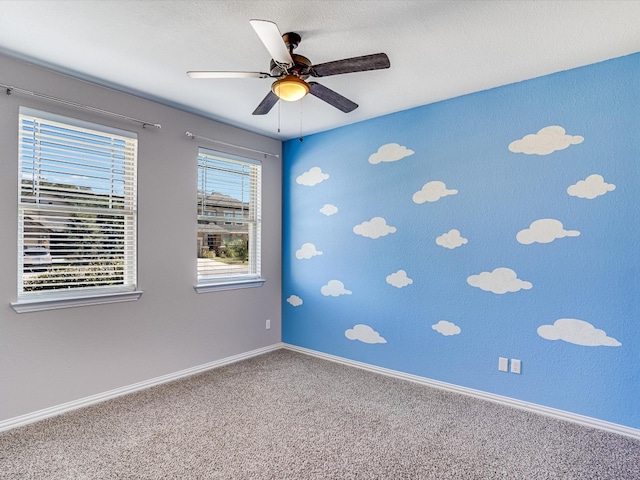 carpeted empty room featuring ceiling fan