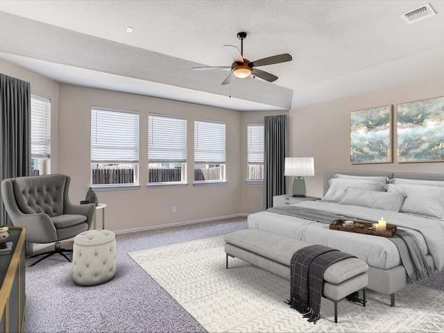 carpeted bedroom with ceiling fan, a textured ceiling, and multiple windows