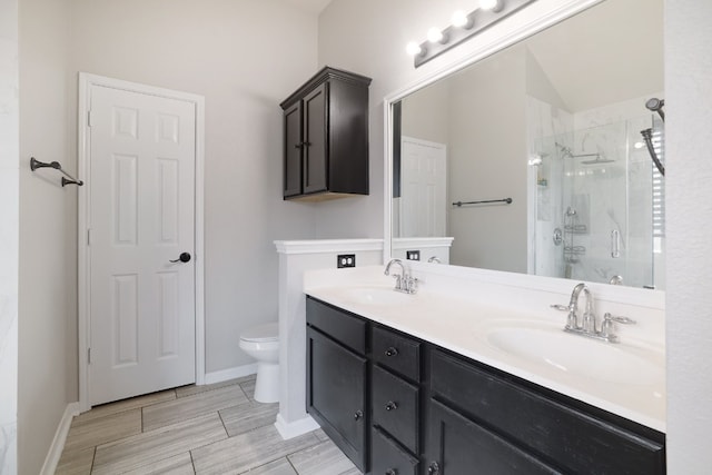 bathroom featuring toilet, vanity, and an enclosed shower