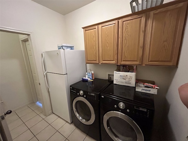 laundry area featuring cabinets, washer and dryer, and light tile patterned flooring