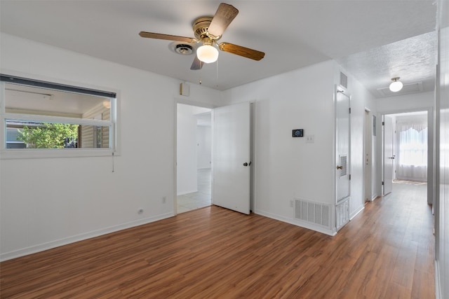 spare room with ceiling fan, a wealth of natural light, and hardwood / wood-style floors