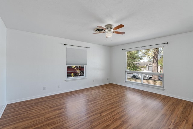 spare room featuring dark hardwood / wood-style flooring, a textured ceiling, and ceiling fan