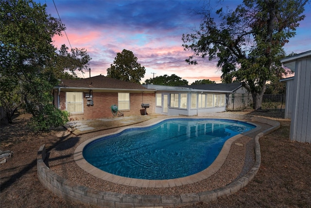 pool at dusk with a patio