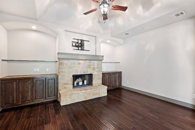 living room featuring ceiling fan, a fireplace, and dark hardwood / wood-style flooring