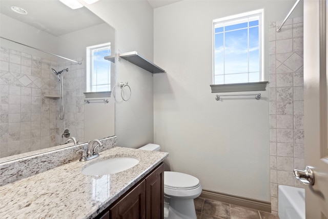 full bathroom with toilet, tiled shower / bath, vanity, and plenty of natural light