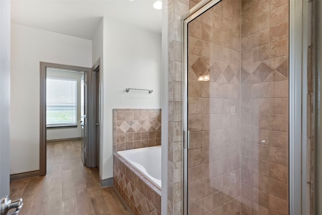 bathroom with hardwood / wood-style floors and plus walk in shower