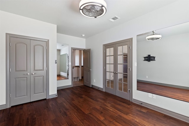 unfurnished bedroom with french doors and dark hardwood / wood-style flooring