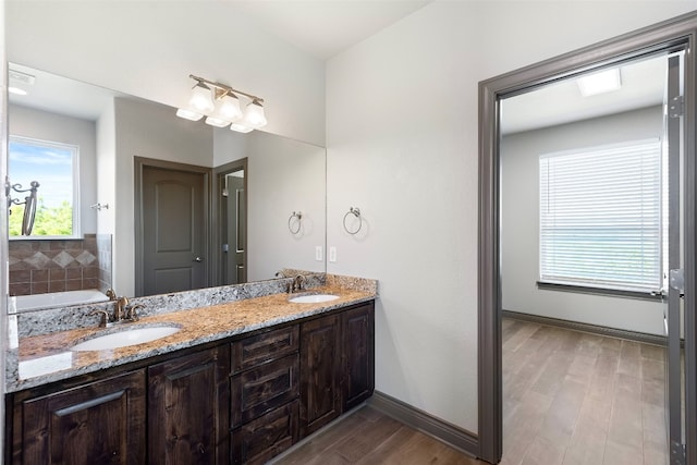 bathroom with vanity, a tub to relax in, and wood-type flooring