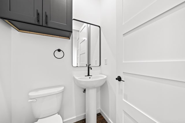 bathroom with hardwood / wood-style flooring and toilet