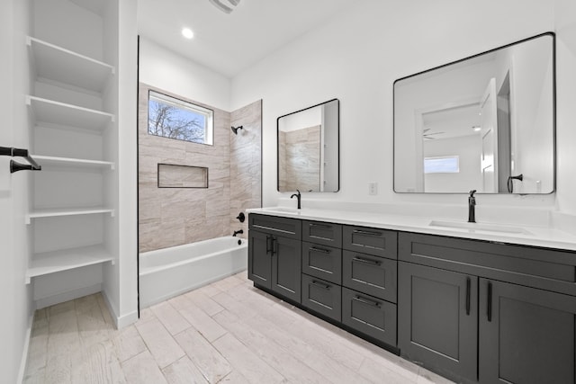 bathroom with vanity, hardwood / wood-style flooring, and tiled shower / bath