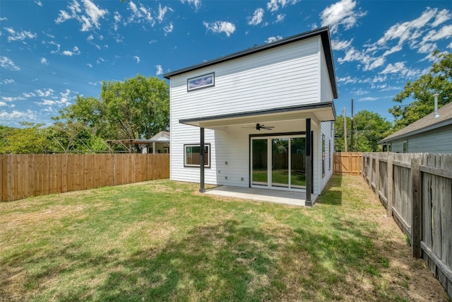 back of property with ceiling fan, a patio area, and a lawn