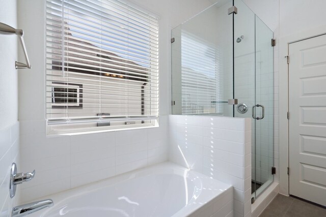 bathroom featuring independent shower and bath, a healthy amount of sunlight, and tile patterned flooring