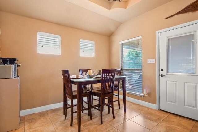 dining room with vaulted ceiling and light tile patterned floors