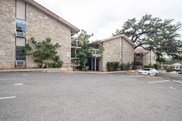 view of property with uncovered parking and cooling unit