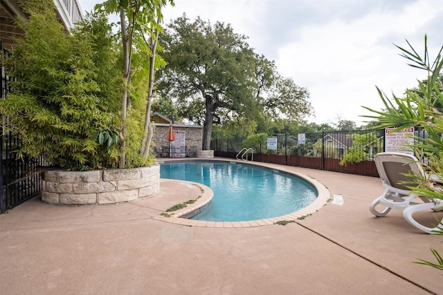 community pool with fence and a patio area