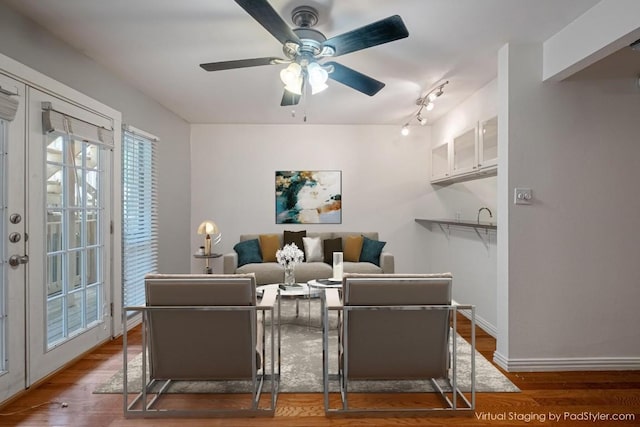 living area with ceiling fan, wood finished floors, and baseboards