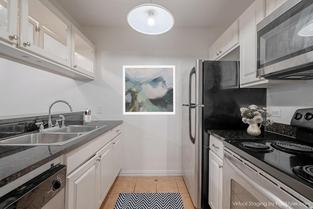 kitchen featuring stainless steel microwave, electric range, dishwashing machine, a sink, and white cabinetry