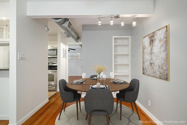 dining room featuring wood finished floors and baseboards
