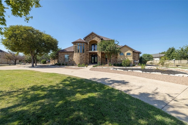 french country inspired facade featuring stone siding and a front lawn