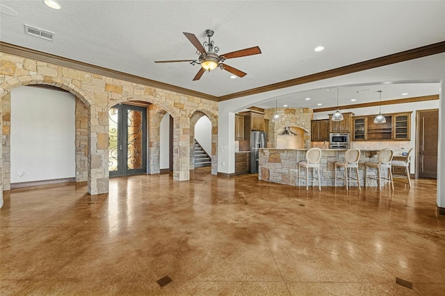 unfurnished living room featuring a textured ceiling, ceiling fan, concrete flooring, and crown molding